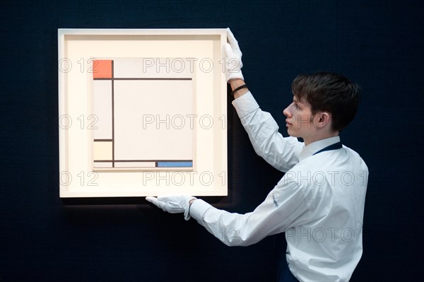 London,UK - 14 June 2013: A Sotheby's employee holds a work by Piet Mondrian entitled “Composition with red, Yellow amd Blue, 1927) (Est. £4.5-6.5 million) during the preview of this summer auction at Sotheby's. Credit:  Piero Cruciatti/Alamy Live News