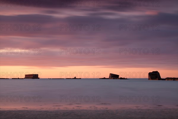 Parts of the remains of the Mulberry Harbour on gold beach Asnelles Calvados Normandy captured at sunset