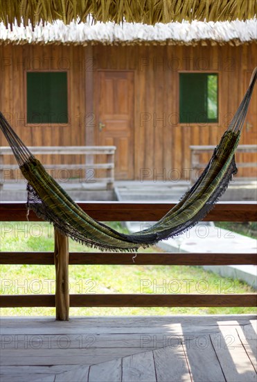 Hammock hanging with a house with two windows at the background and creating a pareidolia of a smiley face