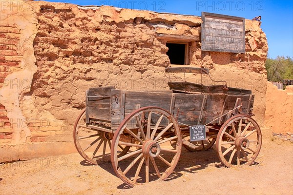 Old wooden wagon outside a building at the Old Tucson Film Studios amusement park in Arizona