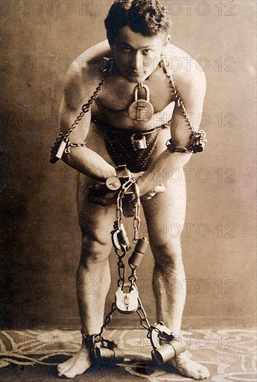 Harry Houdini, full-length portrait, standing, facing front, in chains, circa 1899.  File Reference # 1003_079THA