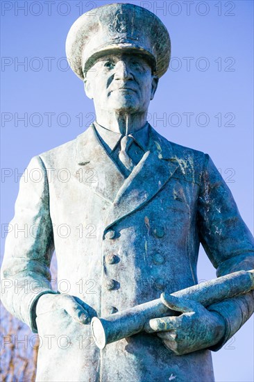 Close up, statue of Vice Admiral Ramsay on the cliff top at Dover castle.Standing with one hand in pocket and the other holding a telescope. Blue sky.