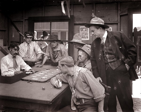 1890s 1900s 1910s FARO CARD GAME MEN PLAYING GAMBLING IN OLD WILD WEST SALOON silent movie still uncorrected glass plate - asph106 ASP001 HARS WILD WEST LIFESTYLE ACTOR HISTORY STUDIO SHOT COPY SPACE HALF-LENGTH PERSONS DANGER MALES RISK WESTERN ENTERTAINMENT DEALER ACTING PLAYERS B&W MOVIES COWBOYS FREEDOM GAMBLING LUCK POKER TURN OF THE 20TH CENTURY CHOICE DRAMATIC EXCITEMENT LUCKY FILM STILLS IN OF SALOON FILM STILL UNLUCKY ACTORS DRAMA GAMBLE SILENT MOVIE GAMBLERS MOTION PICTURE PUBLICITY STILL STILLS MOVIE STILL BET BLACK AND WHITE CAUCASIAN ETHNICITY CHANCE OLD FASHIONED