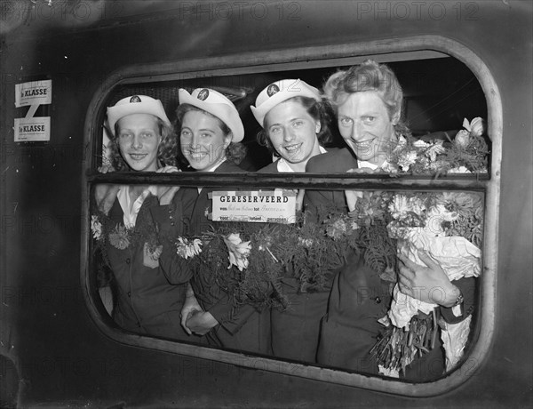 The Dutch 4 x 100 m team, Olympic champion 1948 in London. Arrival in Hoek van Holland. V.l.nr. Xenia Stad-de Jong, Nettie Witziers-Timmer, Gerda van der Kade-Koudijs and Fanny Blankers-Koen. Date: 9 August 1948 Location: Hoek van Holland, Zuid-Holland Keywords: athletics, group portraits, sports, trains Personal name: Blankers-Koen, Fanny, Kade-Koudijs, Gerda van der, Stad-de Jong, Xenia, Witziers-Timmer, Nettie