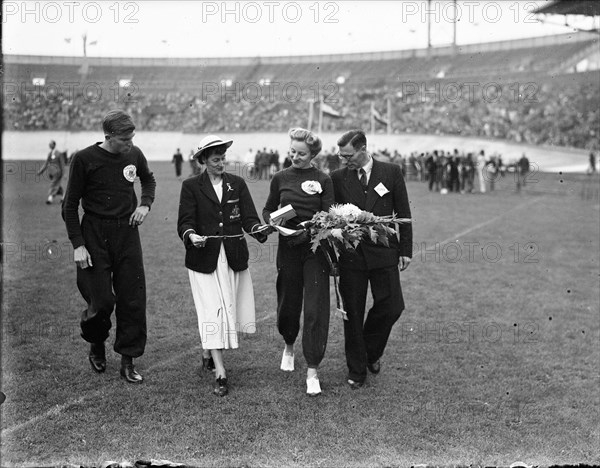 International athletics competition at the Olympic Stadium. Awards Fanny Blankers-Koen. Shirley Strickland and Fanny Blankers-Koen with flowers Date: 13 August 1948 Location: Amsterdam, Noord-Holland Keywords: athletics, athletics, honors, sports Personal name: Blankers-Koen, Fanny, Strickland, Shirley