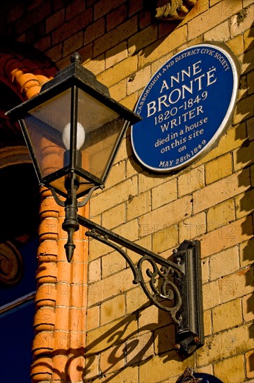 Close up of blue plaque to writer Anne Bronte and ornate lantern lamp on wall of The Grand Hotel Scarborough North Yorkshire England UK Great Britain