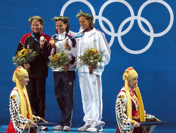 KRT SPORTS STORY SLUGGED: OLY-SWIMMING KRT PHOTO BY KARL MONDON/CONTRA COSTA TIMES (August 16) ATHENS, GREECE  -- Gold medalist Natalie Coughlin, center, stands with silver medalist Kirsty Coventry of Zimbabwe and bronze medalist Laure Manaudou of France after the 100-meter backstroke on Monday, August 16, 2004, during the 2004 Olympic Games in Athens, Greece. (gsb) 2004 (Credit Im