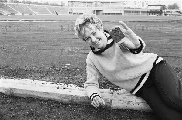 That 2.5 inch square section of track that Lillian Board is holding could help her win a gold medal in the Olympic Games in October 1968. It is the first part of the £67,000 all weather track at Crystal Palace that should be ready for the Great Britain Ol