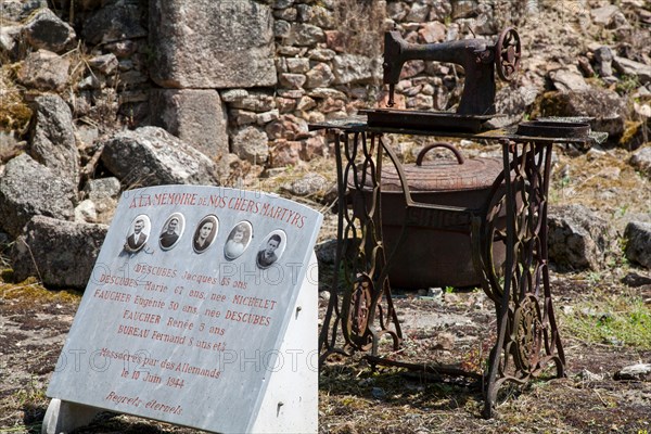 Rusting sewing machine next to memorial plaque in village of Oradour sur Glane, Haute Vienne, France