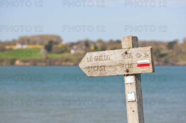 The old wooden sign shows coastal hikers the way to Saint Cast le Guildo along the GR34 long-distance hiking trail between St. Malo and Cap Frehel, Brittany, France