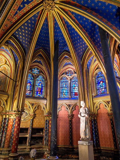 Statue of Saint Louis in Sainte Chapelle: Extravagant arches gilded with gold in a deep blue ceiling frame a statue of Statue of Saint Louis Louis IX at the front of the lower floor of the famous chapel.