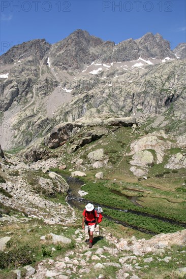 Walker climbing above Valle de la Fous in the French Mercantour national Park, Alpes Maritimes