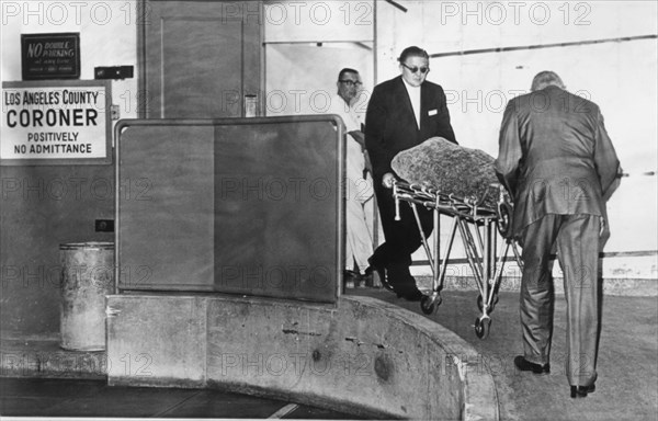 1962 , 6 august , LOS ANGELES , USA : The body of american actress MARILYN MONROE ( 1926 - 1962 ) wrapped in blankets , is wheeled from the Los Angeles County Morgue and en route to the Westwood Village Mortuary in West Los Angeles where funeral services will be held the day 8 august  . - CINEMA - movie - portrait - ritratto - blond hair - capelli biondi  - sex symbol - sex-symbol  - DIVA - DIVINA  - cadavere - corpse - death - morte - morta - dead - coroner - sala mortuaria - autopsia -  --- Archivio GBB