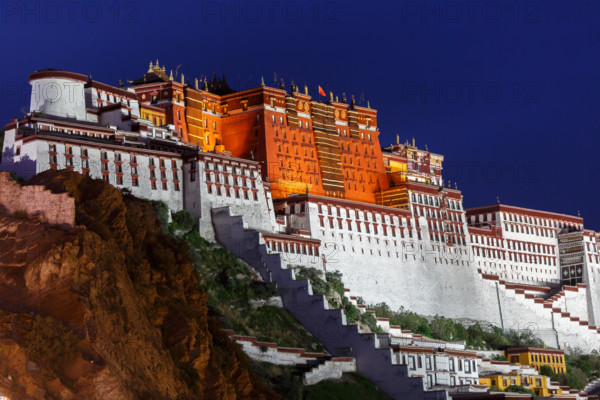 Potala Palace at night. A Chinese flag is waving on top of the palace. Prior home of the Dalai Lama. Potala Palace is an Unesco world heritage site.