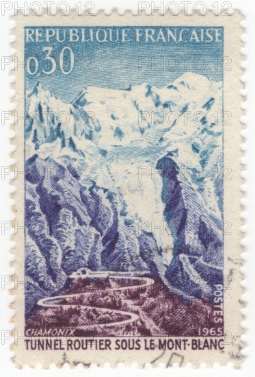 FRANCE - 1965 July 17: An 30 centimes blue, violet-blue and brown-violet postage stamp depicting Road and tunnel, Mont Blanc. For the opening of the Mont Blanc Tunnel, a highway tunnel between France and Italy, under the Mont Blanc mountain in the Alps. The passageway is one of the major trans-Alpine transport routes, particularly for Italy, which relies on this tunnel for transporting as much as one-third of its freight to northern Europe. It reduces the route from France to Turin by 50 kilometres and to Milan by 100 km