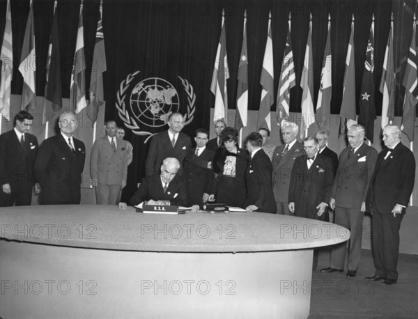 San Francisco, California: June 26, 1945 President Truman (second from left) looks on proudly as Secretary of State Edward Stettinus signs the United Nations Charter.