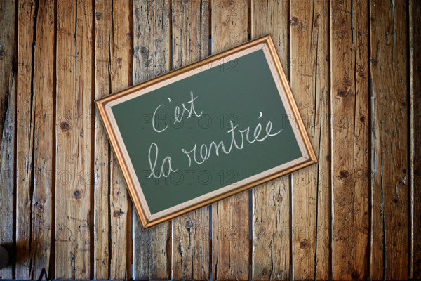 Wooden textured table from above and back to school concept in french