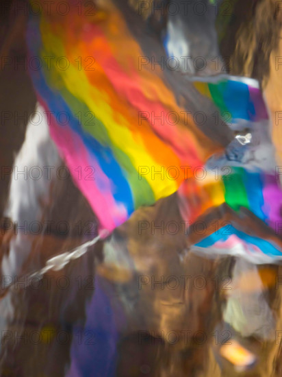 Abstract rainbow gay flag reflected in water in Canal Street Manchester