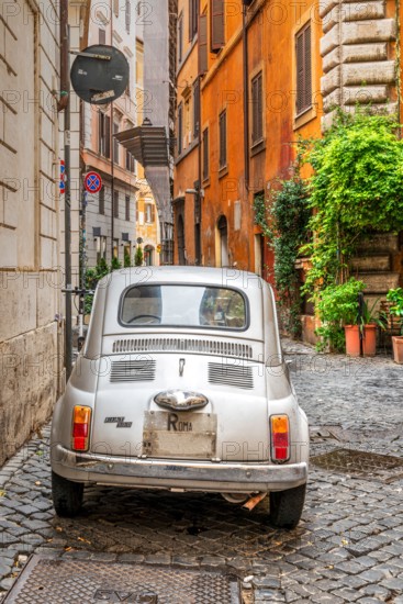 Old classic Fiat 500 car parked in a cobbled street of Rome, Lazio, Italy
