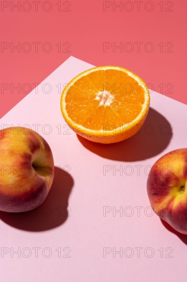 Orange fruit with peaches on bright background. Minimal food concept.