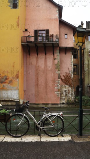 a classic street lantern next to a bicycle in front of the river against the backdrop of a traditional building, Annesy, France