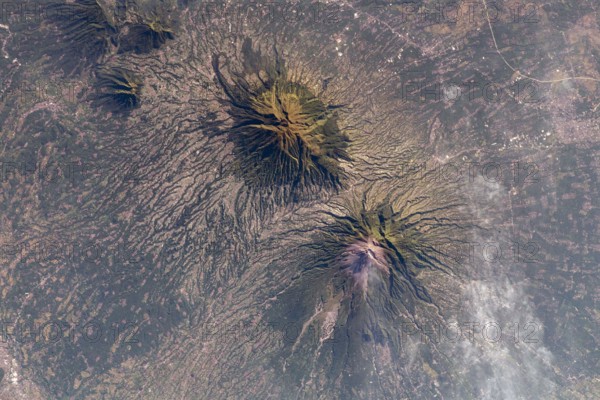 The Earth seen from the International Space Station: A smoking Mount Merapi (lower) and Mount Merbabu (top), Java, Indonesia, 10 May 2021. Mount Merapi is a highly active volcano in Central Java. An optimised and enhanced version of a NASA image / credit NASA.