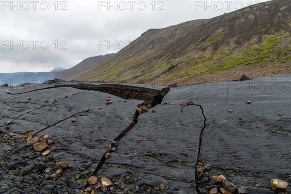 Close up view of cracked lava crust or ingenious rock, cooled down from 2021 eruption of volcano Mt. Fagradalsfjall in Geldingadalir valley on Reykjan