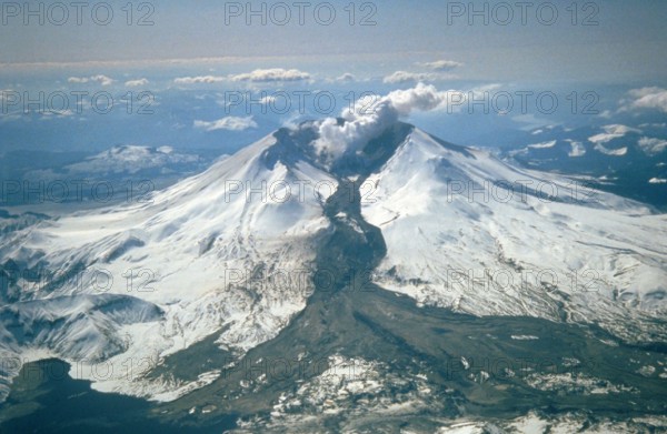 Mount St. Helens erupted often between 1980 and 1986. An explosive eruption on March 19, 1982, sent pumice and ash 9 miles (14 kilometers) into the air, and resulted in a lahar (the dark deposit on the snow) flowing from the crater into the North Fork Toutle River valley. Part of the lahar entered Spirit Lake (lower left corner) but most of the flow went west down the Toutle River, eventually reaching the Cowlitz River, 50 miles (80 kilometers) downstream.
