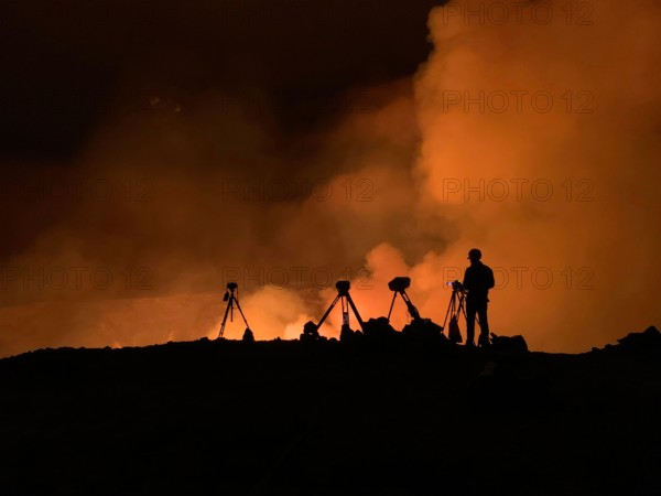 An Hawaiian Volcano Observatory geologist monitoring K?lauea ?volcano is erupting. Hawaii, USA. With the summit eruption continuing through the night, HVO scientists monitor the eruption for changes in activity and volcanic hazards. High levels of volcanic gases are the primary hazard of concern, as this hazard can have far-reaching?effects down-wind. Credit: D. Downs/USGS