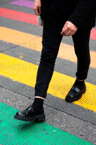 Unrecognizable legs in a rainbow crosswalk in a Gay parade. Rainbow-colored crosswalk installation. LGBTQIA