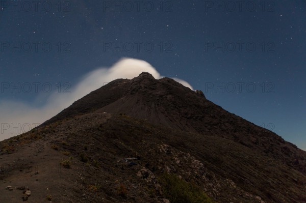 Smoke from Merapi volcano under stars at night.