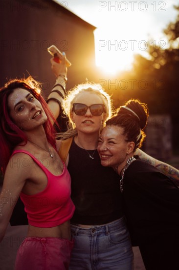 Three happy women friends at sunset, emotional portrait, friendship.