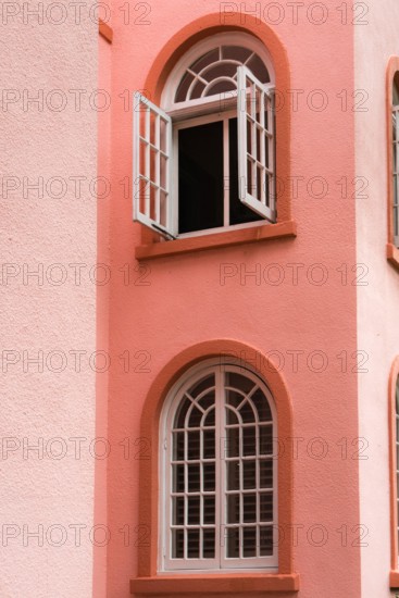 Peach colored vintage building detail exterior with arched windows and doors in the color of peach fuzz.
