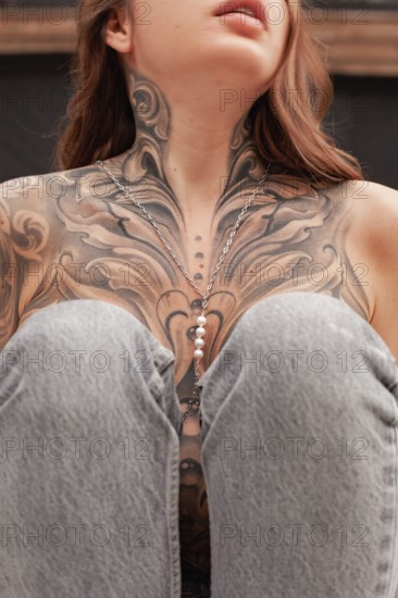 This image captures a close-up view of a womans chest area featuring an elaborate and artistic tattoo, highlighting the details and craftsmanship in n