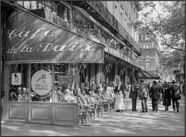 Vintage 1930s Paris Boulevard Restauarant Cafe de la Paix with typical waiter serving. Lifestyle fashion Paris pre war WW2 Photo collection Van de Poll Report / Series : Report Paris Description : Terrace of Café de la Paix on the Boulevard des Capucines Date : 1935 Location : France, Paris