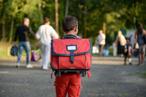 view of a child going to school with a schoolbag on his back on the first day of school in France