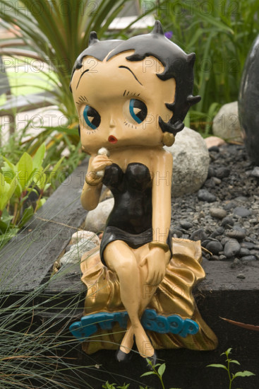 a statue of Betty Boop in a garden