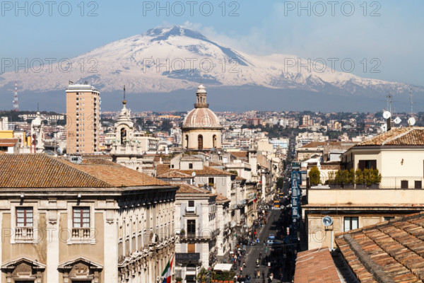 Catania, the central "Via Etnea" street with the snow covered Mount Etna volcano, Sicily, Italy