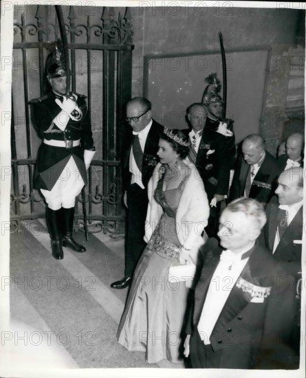 Apr. 04, 1957 - The Queen Attends A Candle-Lit Banquet At The Famous Louvre In Paris. Photo shows Wearing the red sash of the Legion of Honour over her brilliant Kingfisher blue-green dress, the Queen arrives for a candle-lit banquet at the Louvre accompanied by M. Guy Mollet, the French Prime Minister, (left) and M. Pineau (seen behind)