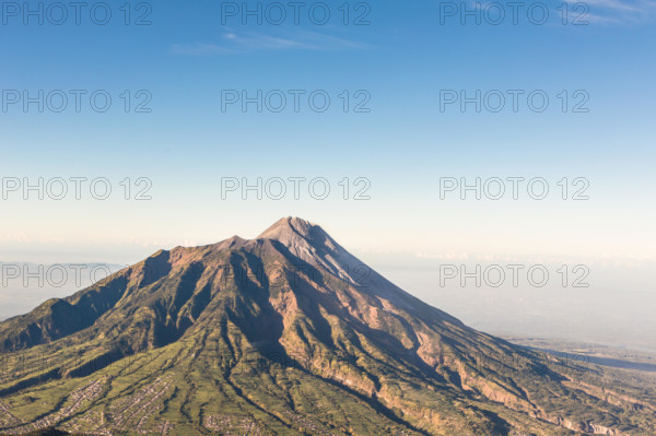 A view of Merapi volcano from the Merbabu volcano near the touristic city of Yogyakarta in central Java in Indonesia