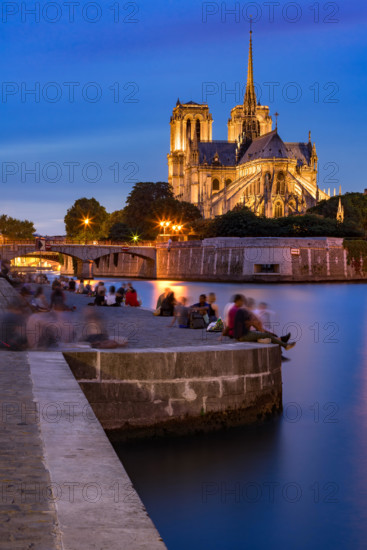 Evening on the Seine River banks in Summer with view of Notre Dame de Paris cathedral