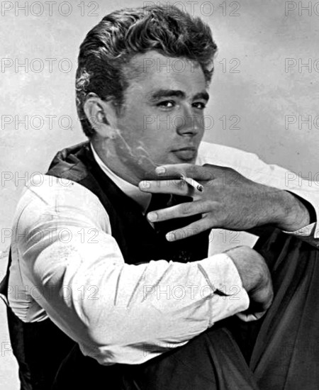 This image likely features James Dean, the iconic American actor, known for his roles in films such as 'Rebel Without a Cause.' The photograph captures him in a relaxed or candid moment, holding a cigarette.