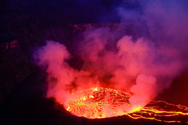 Lava and steam in crater of Nyiragongo volcano in Virunga National Park in Democratic Republic of Congo, Africa. Picture taken during dusk with blue c