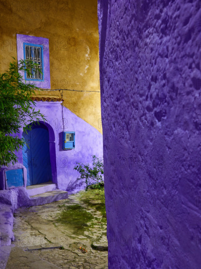 Yellow and violet walls, blue door, fragment of the medina of Chefchaouen, night photography, Morocco.