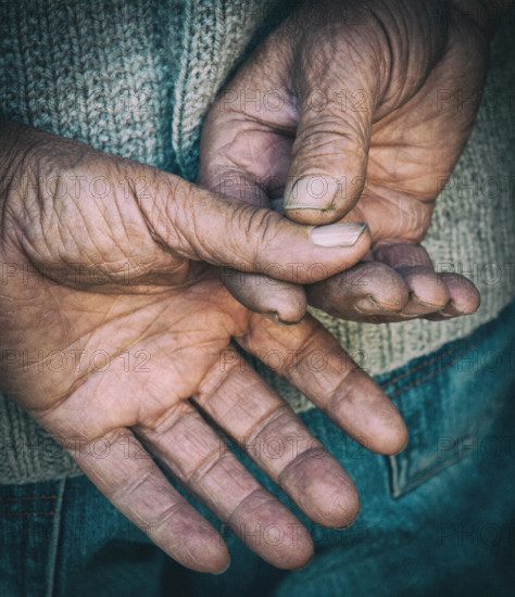 Bare senior adult hands isolated on a black background. Concept of hard worker.