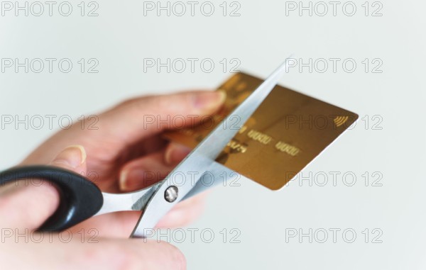Woman cuts credit card with scissors.