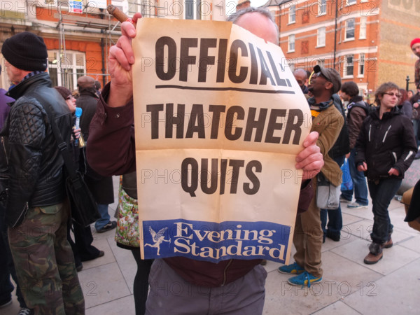 London, UK. 8th April 2013 A man holds up an Evening Standard poster which was apprently from November 1990. It said Official: Thatcher Quits. Credit: nelson pereira / Alamy Live News
