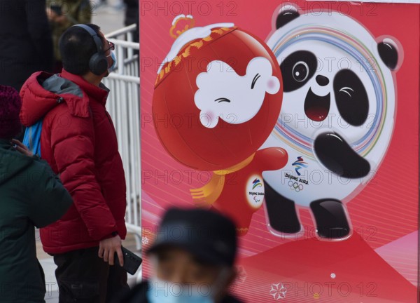 Beijing, China. 10th Feb, 2022. A pedestrian seen looking at the giant poster of Bing Dwen Dwen in Wangfujing Street. The 24th Winter Olympic Games have been held in February 2022 in Beijing, China. The city is full of festive atmosphere with the winter Olympic logo and posters of the mascot "Bing Dwen Dwen" plastered in the streets of Beijing. Credit: SOPA Images Limited/Alamy Live News