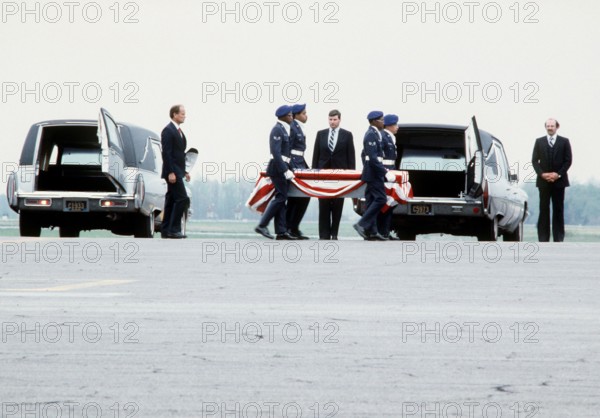 Air Force pallbearers carry a coffin containing the remains of a crew member from the space shuttle Challenger to the back of a hearse. The Challenger exploded shortly after takeoff on January 28, 1986, killing all seven members of its crew. Base: Dover Air Force Base State: Delaware (DE) Country: United States Of America (USA)