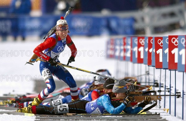 Competing in the Biathlon event, National Guard SPECIALIST (SPC) Kara Salmela, USA, with her .22 caliber, bolt-action rifle slung on her back, jumps from the prone position, skies in hand, leaves the shooting range for the first time at Soldier Hollow after hitting all five targets during the women's 10km Pursuit competition in the 2002 WINTER OLYMPIC GAMES. SPC Salmela finished the race 45th overall, 6:00.0 behind the leader. Subject Operation/Series: 2002 WINTER OLYMPIC GAMES Base: Salt Lake City State: Utah (UT) Country: United States Of America (USA)
